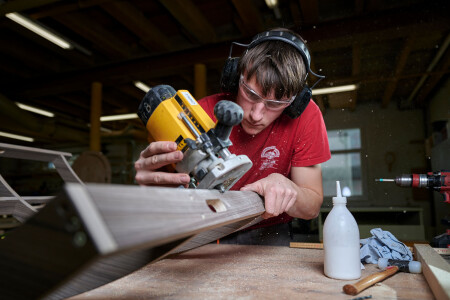 Un menuisier broie un morceau de bois